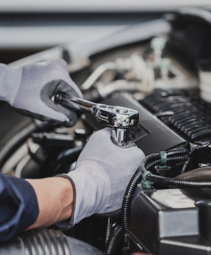 Mains qui réparent une voiture